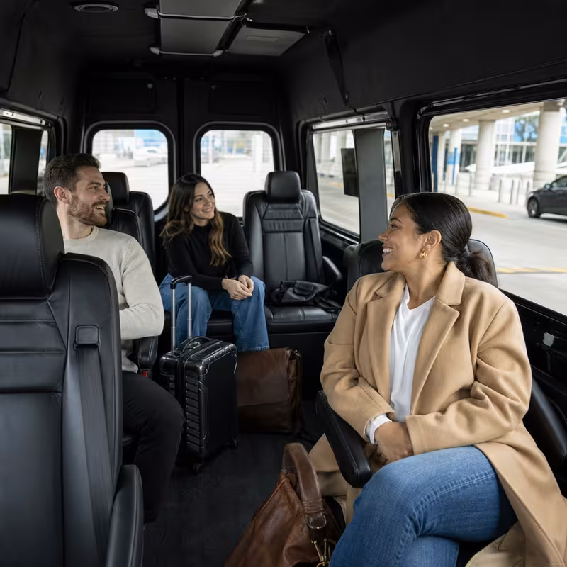 Passengers loading luggage while boarding an Austin group shuttle