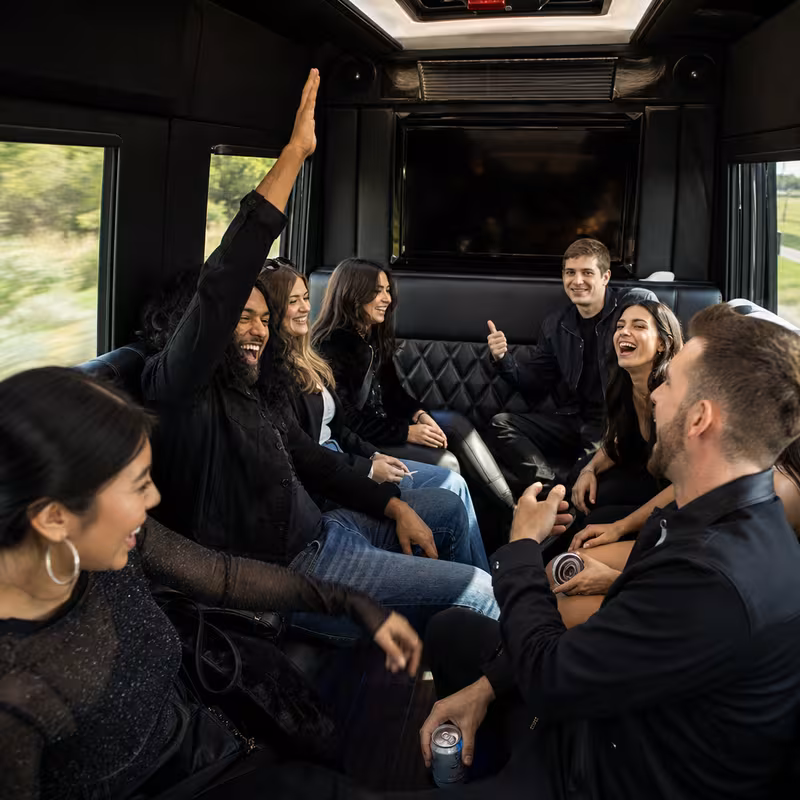 Group boarding a white charter bus for Concert Transportation transportation in Austin