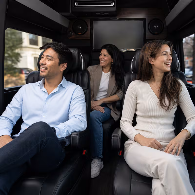 Group boarding a white charter bus for Corporate Transportation transportation in Austin