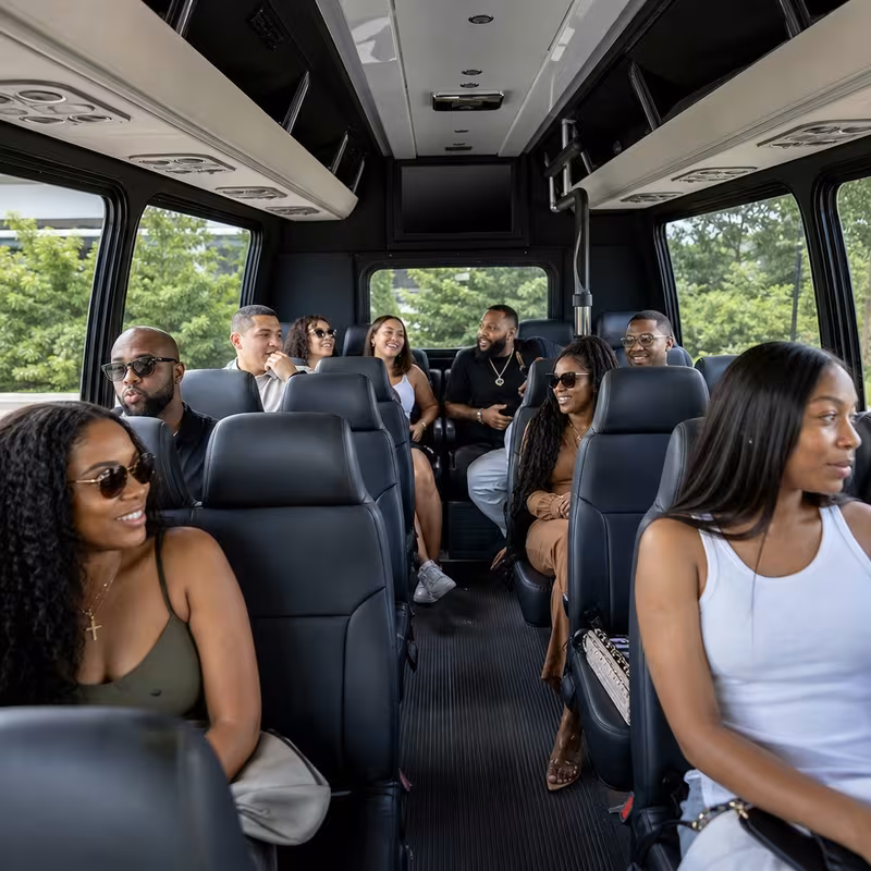 Group boarding a white charter bus for Private Event Transportation transportation in Austin