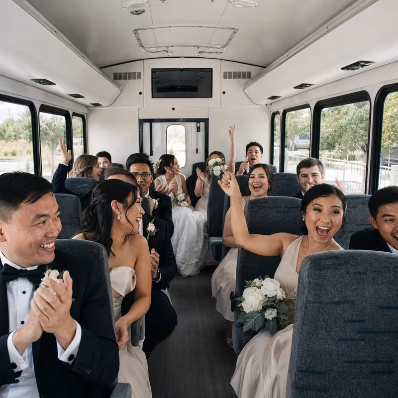 Group boarding a white charter bus for Wedding Transportation transportation in Austin